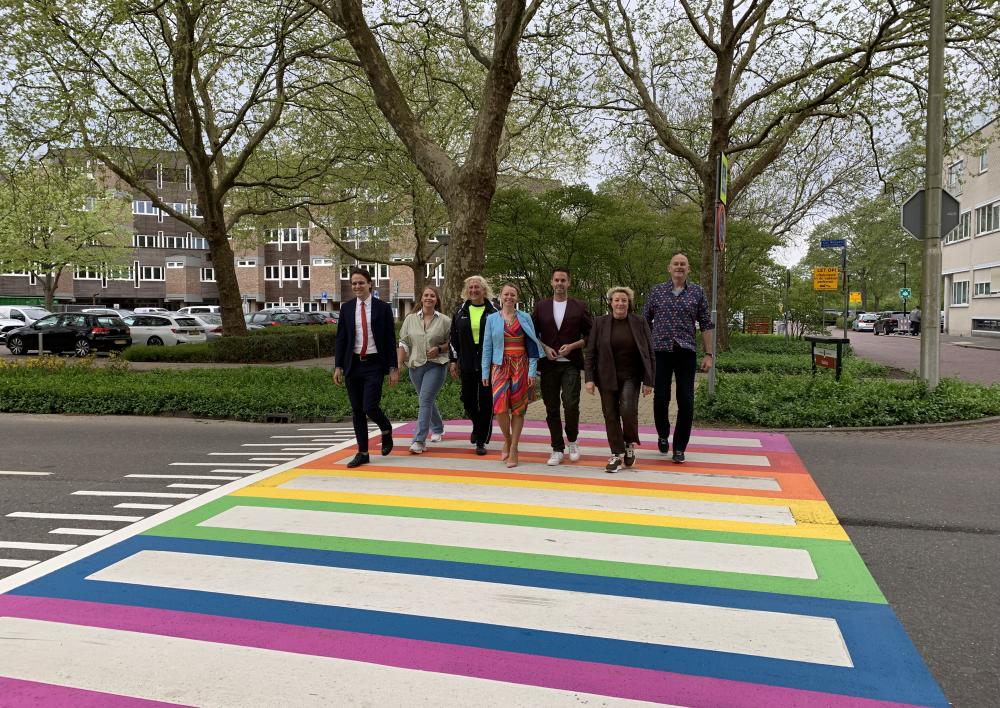 Wethouders lopen over de regenboogzebra met raadsleden
