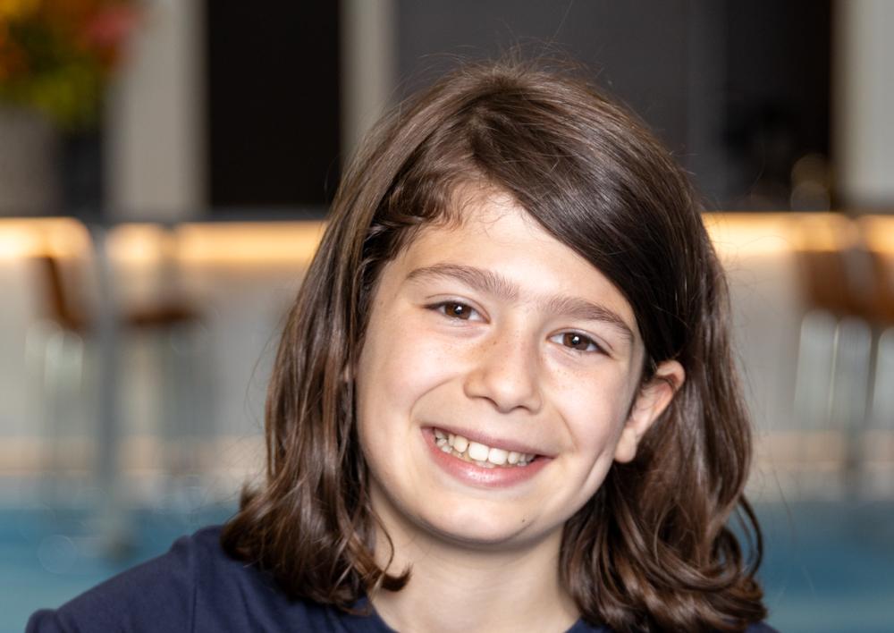 De nieuwe kinderburgemeester Levi zit op de bank en lacht