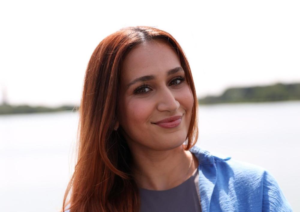 Youssra kijkt je lachtend aan met op de achtergrond het water vande Poel