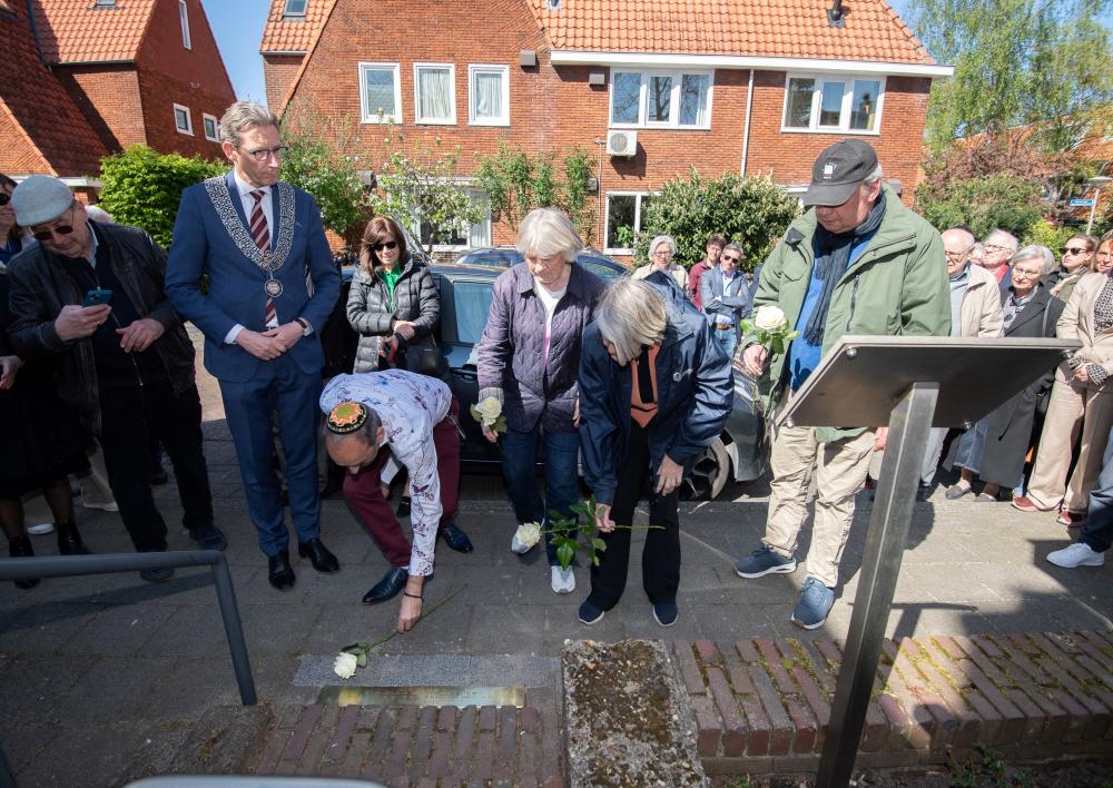 Burgemeester Tjapko Poppens en leden van de werkgroep Randwijcklaan 13 leggen rozen bij de Stolperdrempel.