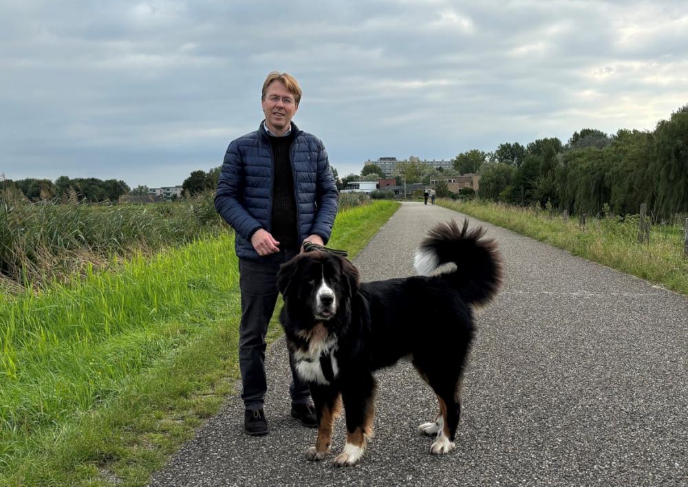 Menno van Leeuwen met zijn hond buiten op een pad