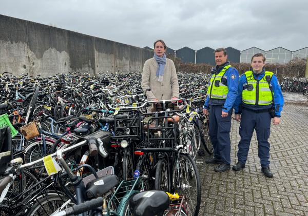 Wethouder Herbert Raat bij de gemeentelijke opslag van weesfietsen.