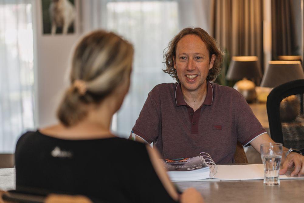Energiecoach en bewoner aan tafel
