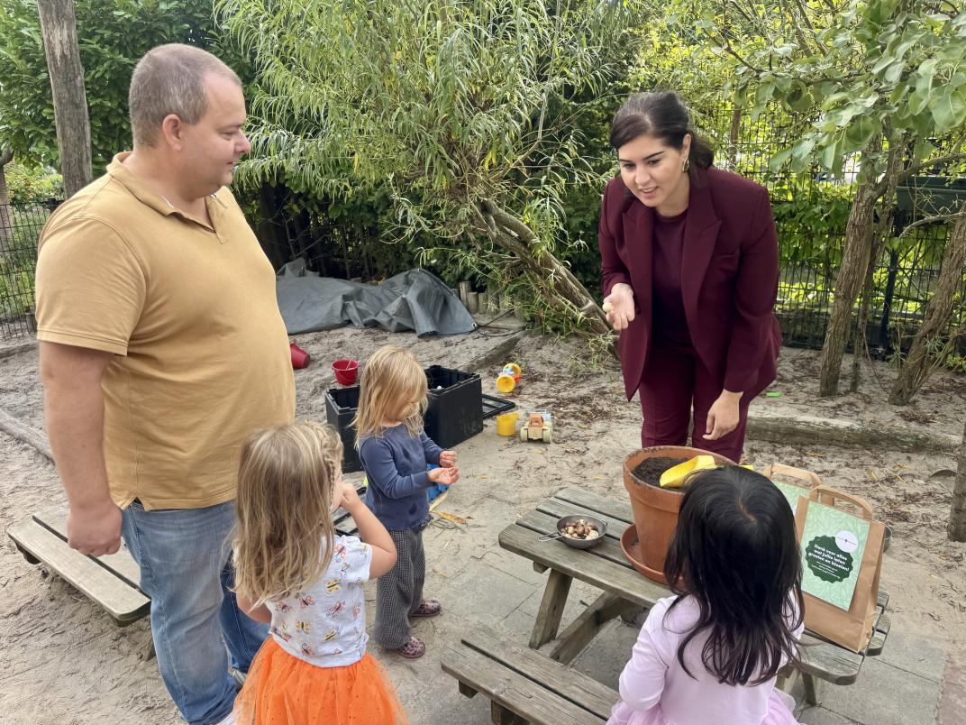 Wethouder, kinderen en directeur planten bloembollen